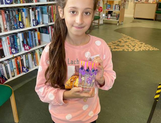 Girl in library holding glass