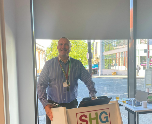 Funding Officer stood in front of an SHG lectern